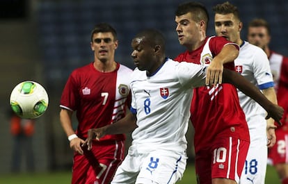El eslovaco Karim Guede es marcado por el gibraltareño Liam Walker mientras intentan controlar un balón.