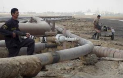 Un oficial de seguridad y un obrero trabajan en un oleoducto de una refinería del pueblo de Umm Quasar en Basora, Irak. EFE/Archivo