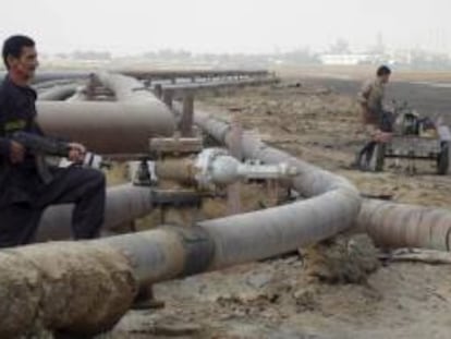 Un oficial de seguridad y un obrero trabajan en un oleoducto de una refinería del pueblo de Umm Quasar en Basora, Irak. EFE/Archivo