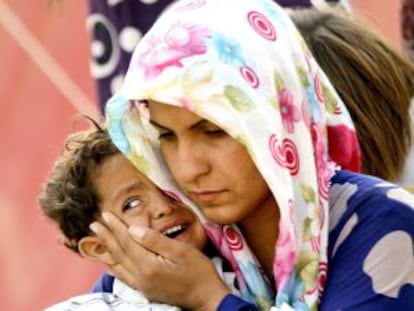 Una refugiada siria consuela a su hijo en la frontera con Turqu&iacute;a.