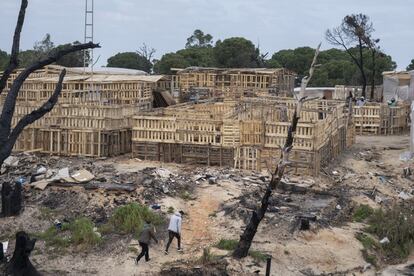 Tras el incendio, los vecinos del asentamiento chabolista de Palos de la Frontera hacen acopio de palés para la reconstrucción de sus infraviviendas.