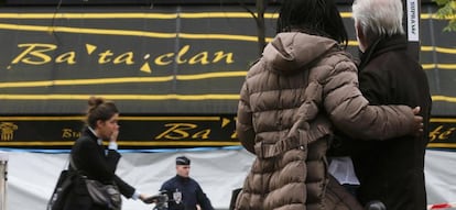 Dos personas se abrazan frente a la sala Bataclan, uno de los escenarios del atentado terrorista del viernes 13 de noviembre en Par&iacute;s.