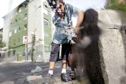 Un niño refrescándose en el barrio de San Blas.