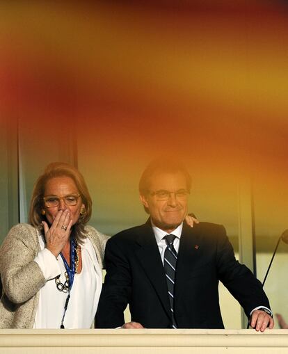 Artur Mas y su esposa, Helena Rakosnik, saludan desde el balcón del hotel Majestic.