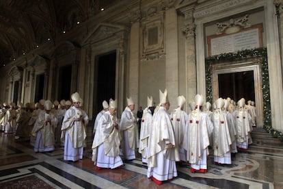 Cardenales entran por la Puerta Santa en el Vaticano.