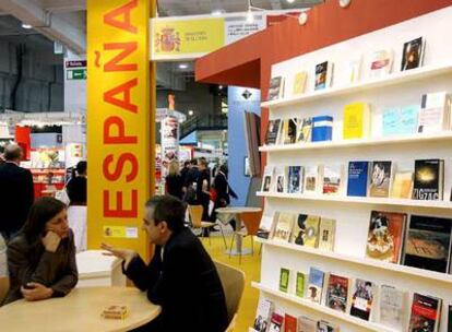 Dos personas conversan en el expositor de España en la Feria del Libro de Londres.