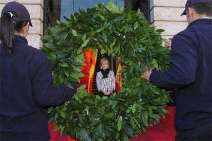 Una corona de laurel es colocada ante la placa que recuerda a quienes trabajaron desinteresadamente el 11-M en la sede de la Comunidad de Madrid en la Puerta del Sol.