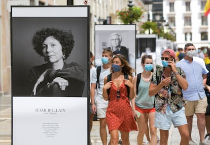 Paseantes, ayer al mediodía, por la calle Larios, en Málaga, donde se ha instalado una exposición de fotografías dedicada al festival.