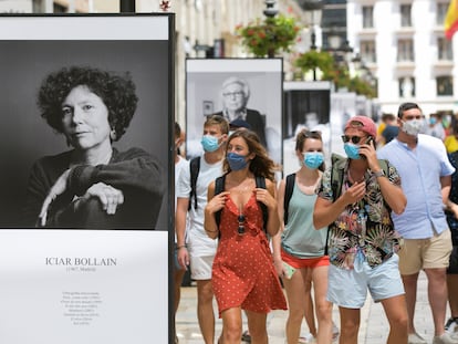 Paseantes, ayer al mediodía, por la calle Larios, en Málaga, donde se ha instalado una exposición de fotografías dedicada al festival.