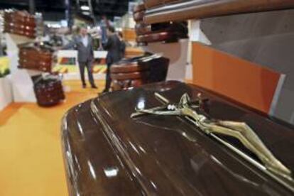 Un vendedor muestra a dos clientes diferentes modelos de ataúdes en Funermostra, la Feria Internacional de Productos y Servicios Funerarios, que se celebra en Valencia. EFE/Archivo