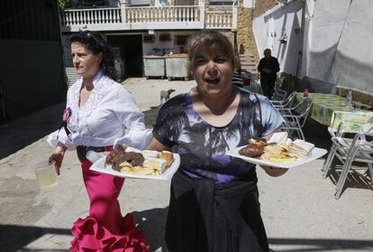 Unas vecinas ofrecen paseteles y rebujito a la entrada del sector 3.