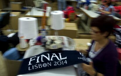 Una mujer cose una bufanda del Real Madrid y el Atlético de Madrid en una empresa textil en Vizela (Portugal). La empresa portuguesa ha fabricado alrededor de 30.000 bufandas oficiales para la próxima final de la Champions League del sábado 24 de mayo.