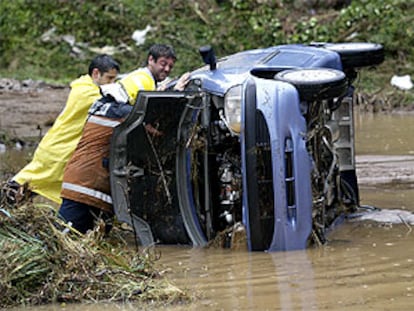 Coche volcado por la lluvias en Barcelona.