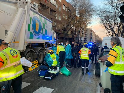 Samur y policía atienden a la mujer junto al camión de la basura.