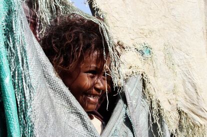 Una niña se asoma a la puerta de su casa en el campo de desplazados de Abys (Yemen).