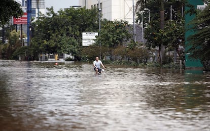 Un hombre pasea en bicicleta por una calle inundada en Yakarta (Indonesia), tras las fuertes lluvias caídas en los últimos días.