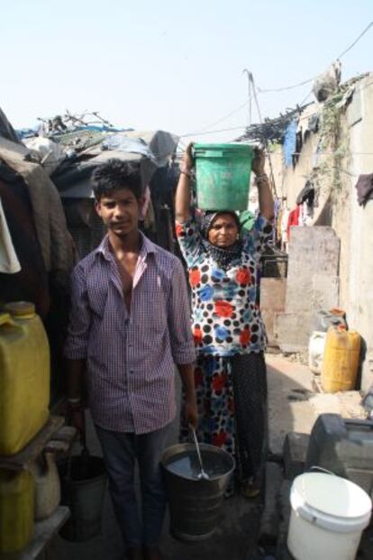 Una mujer y un hombre transportan agua en Nueva Delhi.