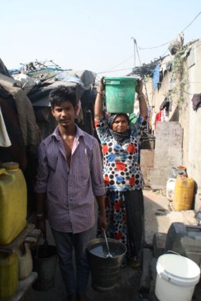 Una mujer y un hombre transportan agua en Nueva Delhi.
