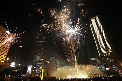 Los habitantes de Jakarta se reúnen alrededor de la fuente de la Estatua de la Bienvenida para ver la fiesta de fuegos artificiales