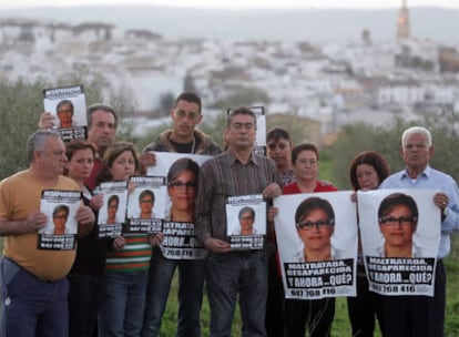 Un grupo de familiares de Ángeles Zurera muestra el pasado viernes carteles con la imagen de la desaparecida, con su pueblo, Aguilar, al fondo.