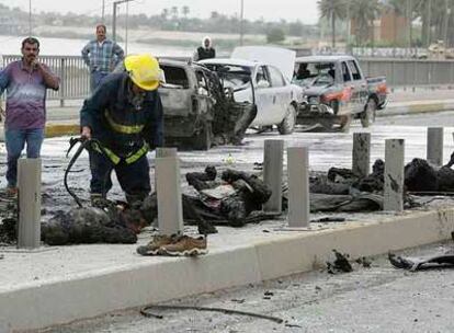Un bombero trabaja sobre los restos de la explosión de una bomba ayer en un puente de Bagdad.