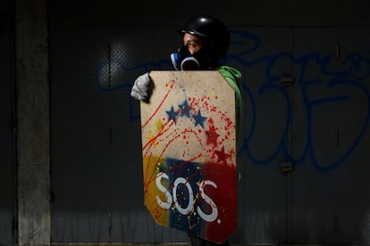 Un manifestante sostiene un escudo rudimentario, mientras posa para un retrato antes de una protesta contra el gobierno del presidente Nicolás Maduro, en Caracas, el 27 de mayo de 2017. 'Protesto por la libertad. Quiero saber que puedo estudiar y aspirar a algo mejor. El régimen nos ha robado todo, la calidad de vida y las oportunidades'.