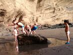 La playa puede ser un espacio de aprendizaje fundamental este verano. En la imagen varios niños, alumnos de la playa escuela El Médano, juegan en los charcos de la playa en un día de escuela.