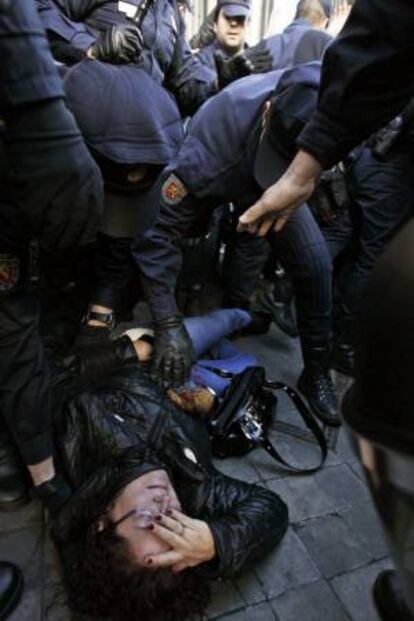 Una mujer tras caer al suelo junto a efectivos policiales durante la movilización ciudadana promovida por el colectivo 'Stop Desahucios' que ha logrado frenar ayer el desalojo de una mujer de 85 años, Aurelia Rey, por el impago de un mes de alquiler de un inmueble en el centro de A Coruña.