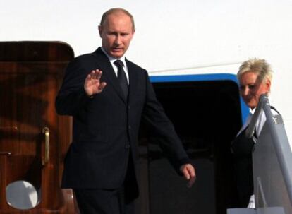 El primer ministro ruso, Vladimir Putin, saluda antes de subir al avión que ayer le devolvía a Moscú tras una visita de un solo día a París, para tratar con Sarkozy la compra de dos barcos de guerra a Francia.