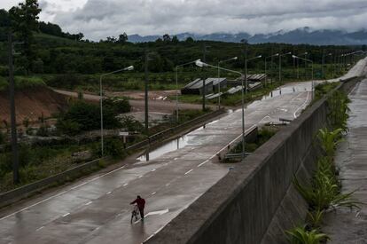 Un hombre empuja su bicicleta por la carretera que conduce al puesto de control de la frontera birmano-tailandesa en Mae Sot. La covid-19 ha tenido graves consecuencias para la vida de miles de trabajadores emigrados a Tailandia, que ven como sus ya difíciles condiciones de vida han empeorado. 