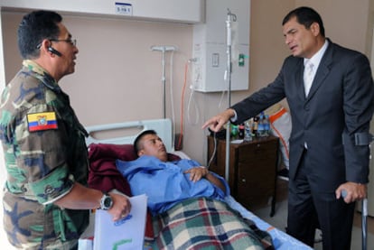 El presidente ecuatoriano, Rafael Correa (derecha), visita a uno de los soldados heridos en el golpe de Estado del jueves.