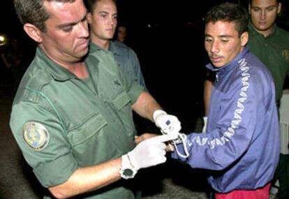 Un agente de la Guardia Civil esposa a un inmigrante, hoy en Fuerteventura.