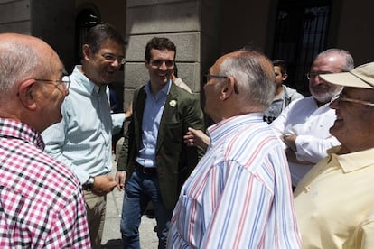 El vicesecretario de Comunicación del PP, Pablo Casado (c), y el ministro de Justicia en funciones y cabeza de lista por Cuenca, Rafael Catalá (i), conversan con vecinos de Ávila, durante su visitaa la ciudad avilesa donde han inaugurado la carpa electoral del Partido Popular.