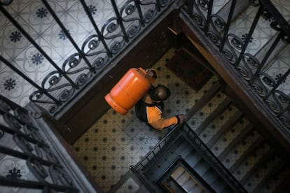 Un butanero sube una bombona a un piso de Barcelona.