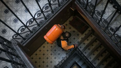 Un butanero sube una bombona a un piso de Barcelona.