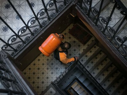 Un butanero sube una bombona a un piso de Barcelona.