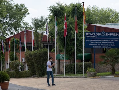 Un joven pasa delante de un cartel en español, inglés, alemán y chino que da la bienvenida a la Universidad Tecnología y Empresa en el campus del Colegio Nuevo Centro, en el distrito de Villaverde de Madrid.