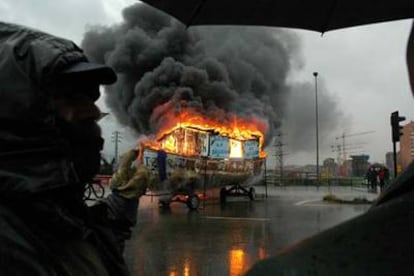 Los trabajadores de Izar queman una barcaza en las calles de Gijón tras una manifestación de protesta.