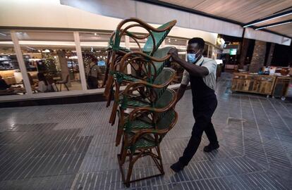 Un camarero recoge la terraza para cerrar a las 23.00 en cumplimiento del toque de queda, este domingo en Palma de Mallorca.