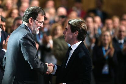 Rajoy saluda a Aznar durante la convención del PP en el Palacio de Congresos de Madrid.