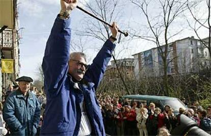 El etarra  Eugenio Etxebeste saluda puño en alto con el bastón de mando que le entregó Periko Solabarria.