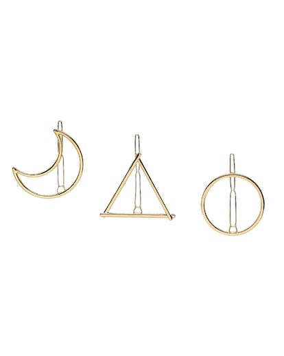 8 by YOOX. Minimal y chapado en oro, este pasador simplifica los elementos para no saturar el peinado. Set de tres piezas  con formas de círculo, triángulo y luna.