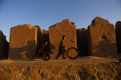 Dos niños juegan con neumáticos a las afueras de Herāt (Afganistán), el 3 de septiembre.