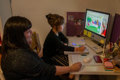 Mar Cadiñanos helping her daughter Vera, seven, with her homework at home in Madrid.
