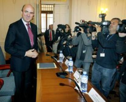 El ministro de Economía y Competitividad, Luis de Guindos (i), momentos antes de su intervención en el seminario "Competitividad y Marca España" que se celebra esta semana en la Universidad Internacional Menéndez Pelayo.