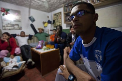 Oscar de 23 años y originario de San Pedro Sula, Honduras, observa en la pantalla el juego de su selección nacional contra Ecuador durante el Mundial de 2014.