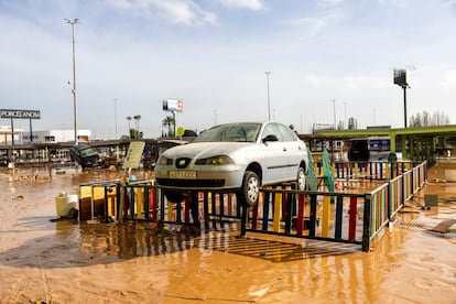 Un coche arrastrado por las inundaciones sobre la valla de un parque de Sedav, este jueves.