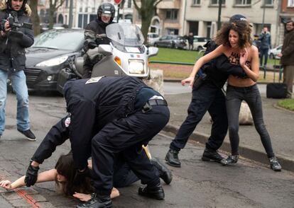 Strauss-Kahn, que mantiene que su carrera política está terminada, afronta una pena de hasta 10 años de prisión y una multa de hasta 1,5 millones de euros en caso de ser condenado. En la imagen, agentes de la policía intentan detener a las activistas de Femen a las puertas de los juzgados.