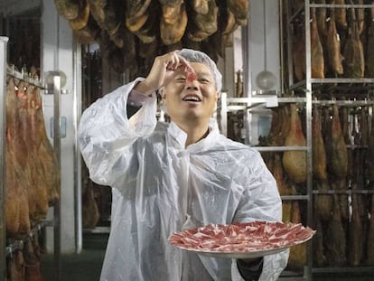 A distributor for the Spanish company Embutidos Fermín tries a piece of ham.