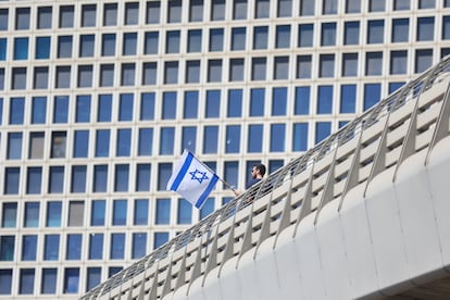 Un hombre alza una bandera israelí durante las protestas en Tel Aviv.